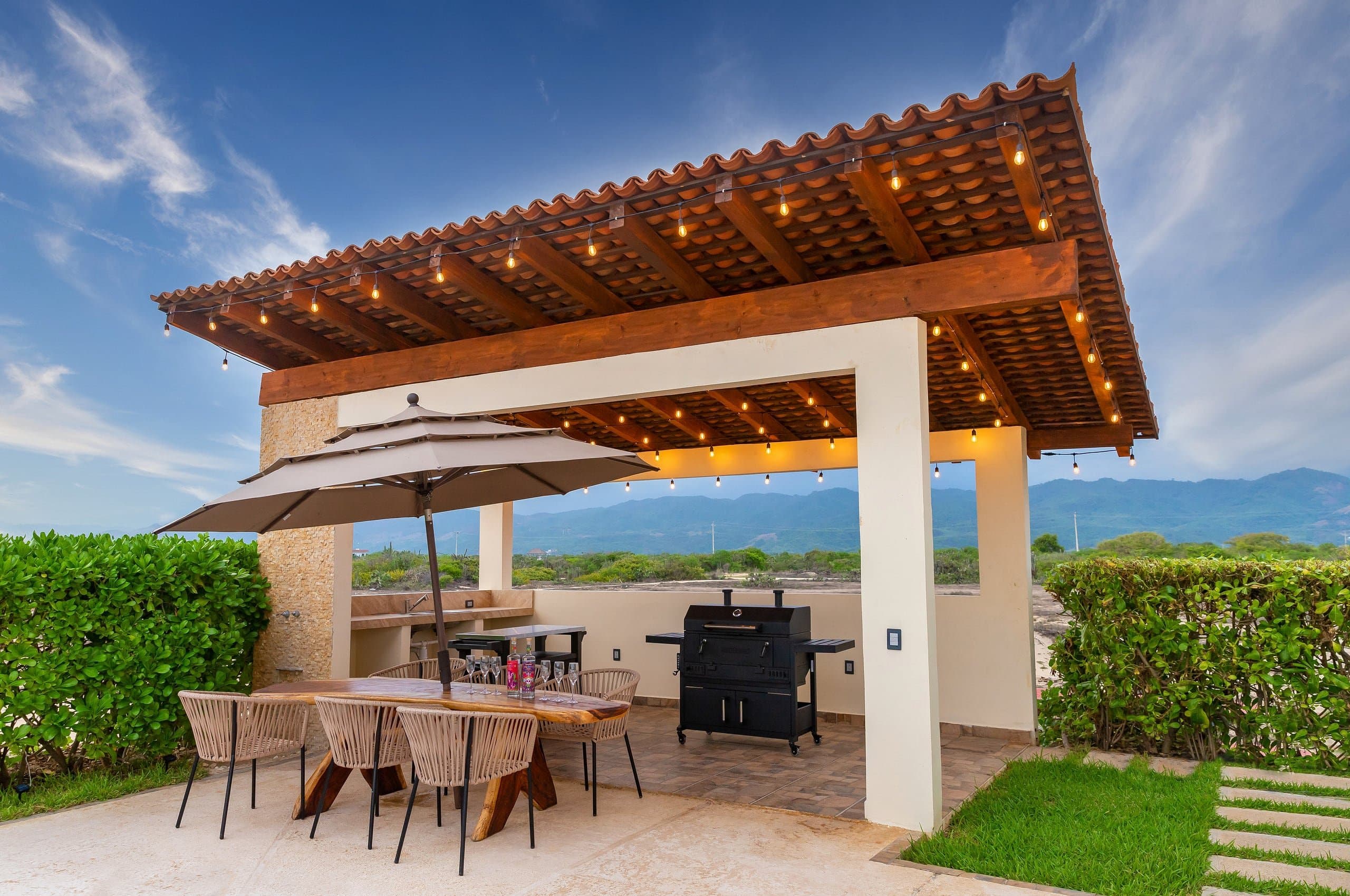 Palapa con comedor exterior y asador junto a la alberca