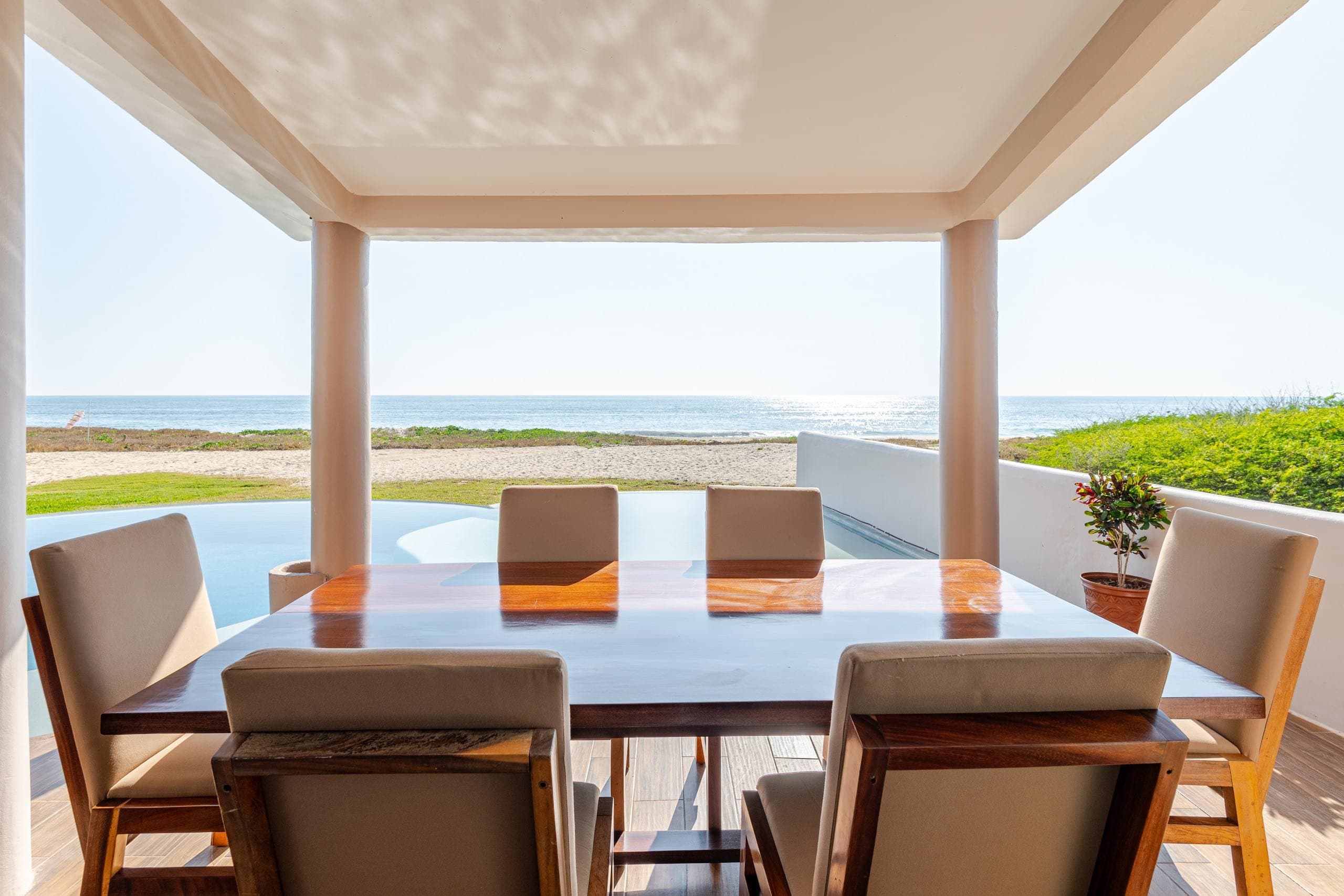 Mesa de comedor bajo techo con vista abierta al mar