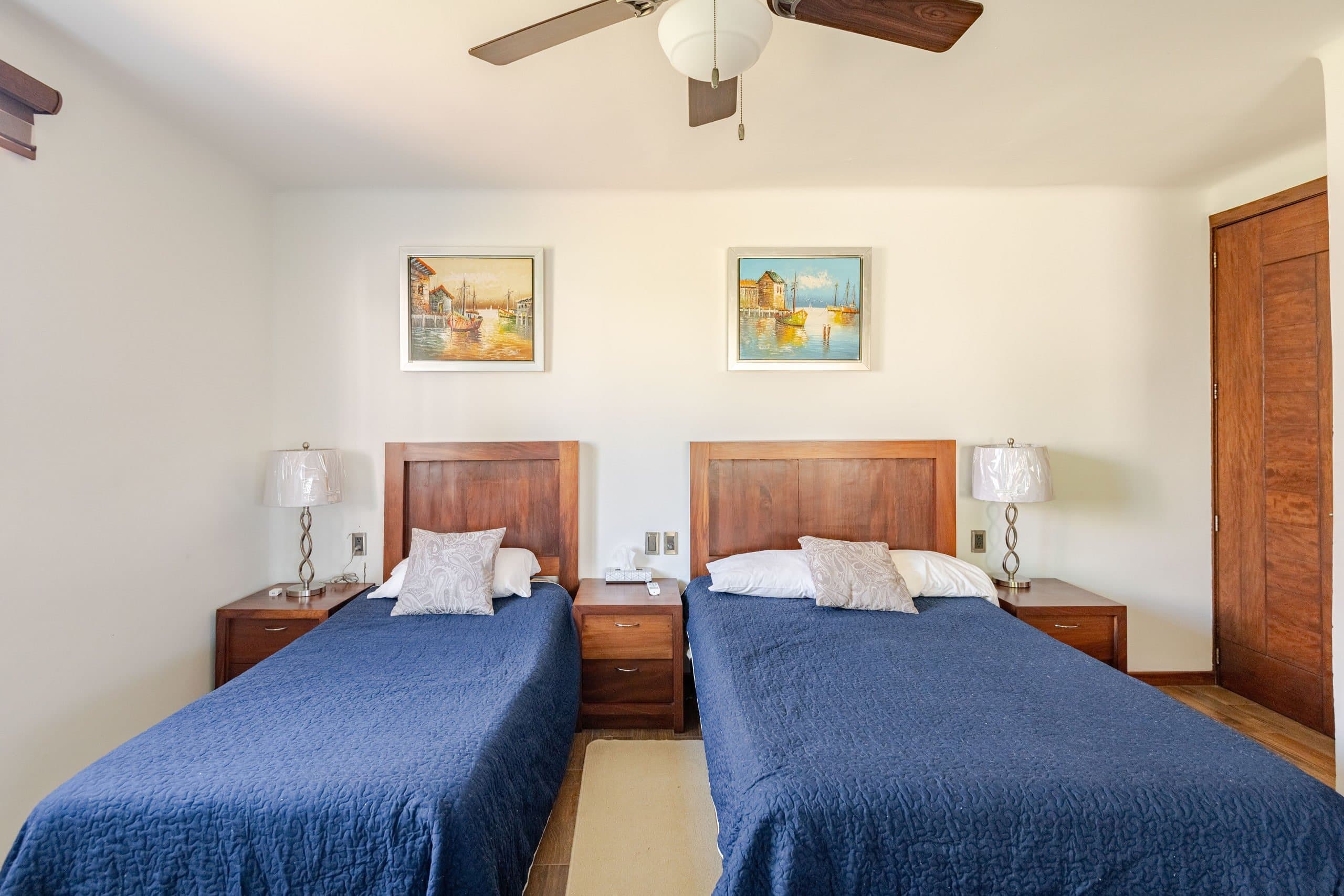 Recámara con dos camas y ropa de cama azul