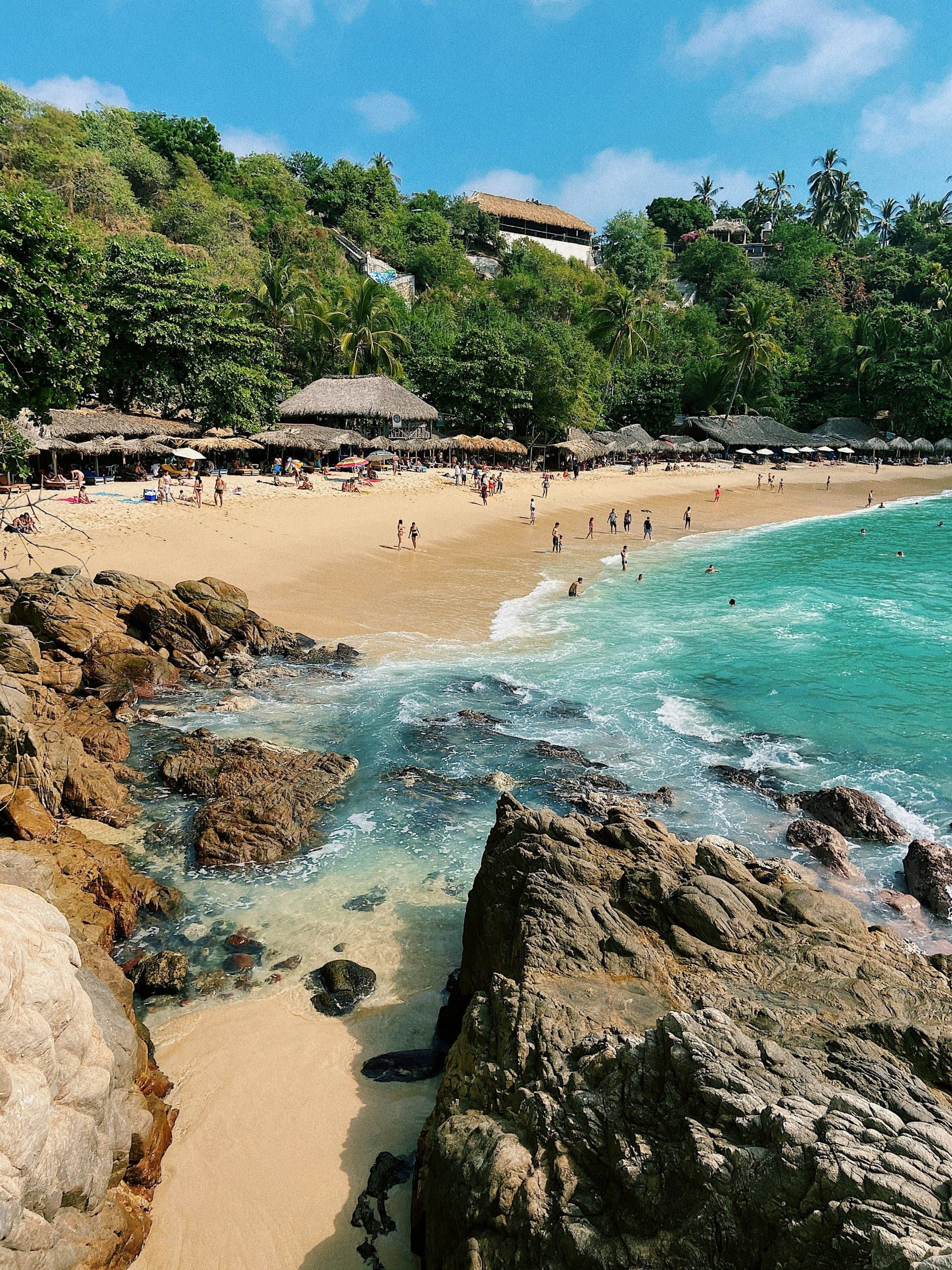 Playa Carrizalillo con palapas, arena y rocas