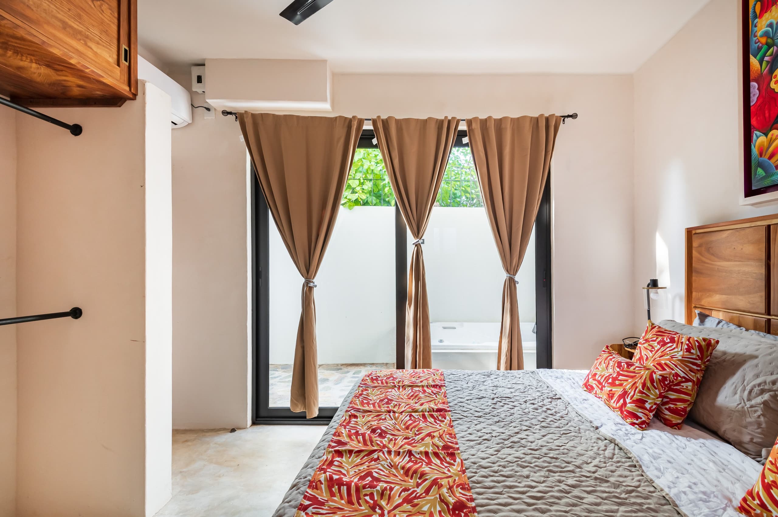 Recámara con cortinas abiertas hacia el patio del jacuzzi privado
